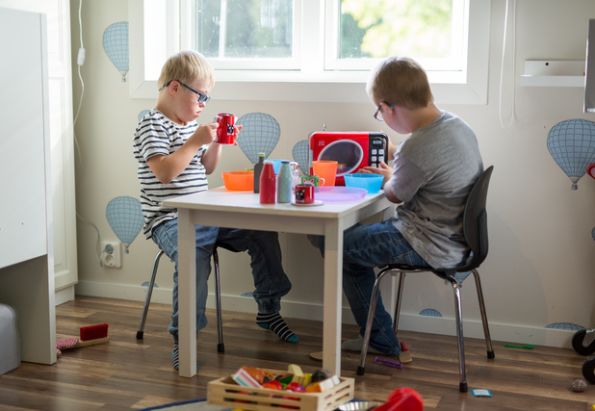 To små gutter med downs syndrom sitter og leker seg i et av Stendis boenheter for utviklingshemmede.
