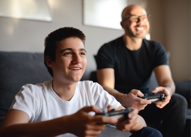 Mann og gutt spiller Playstation sammen