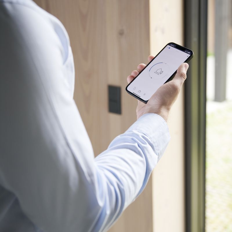 En mann i skjorte som holder en mobil