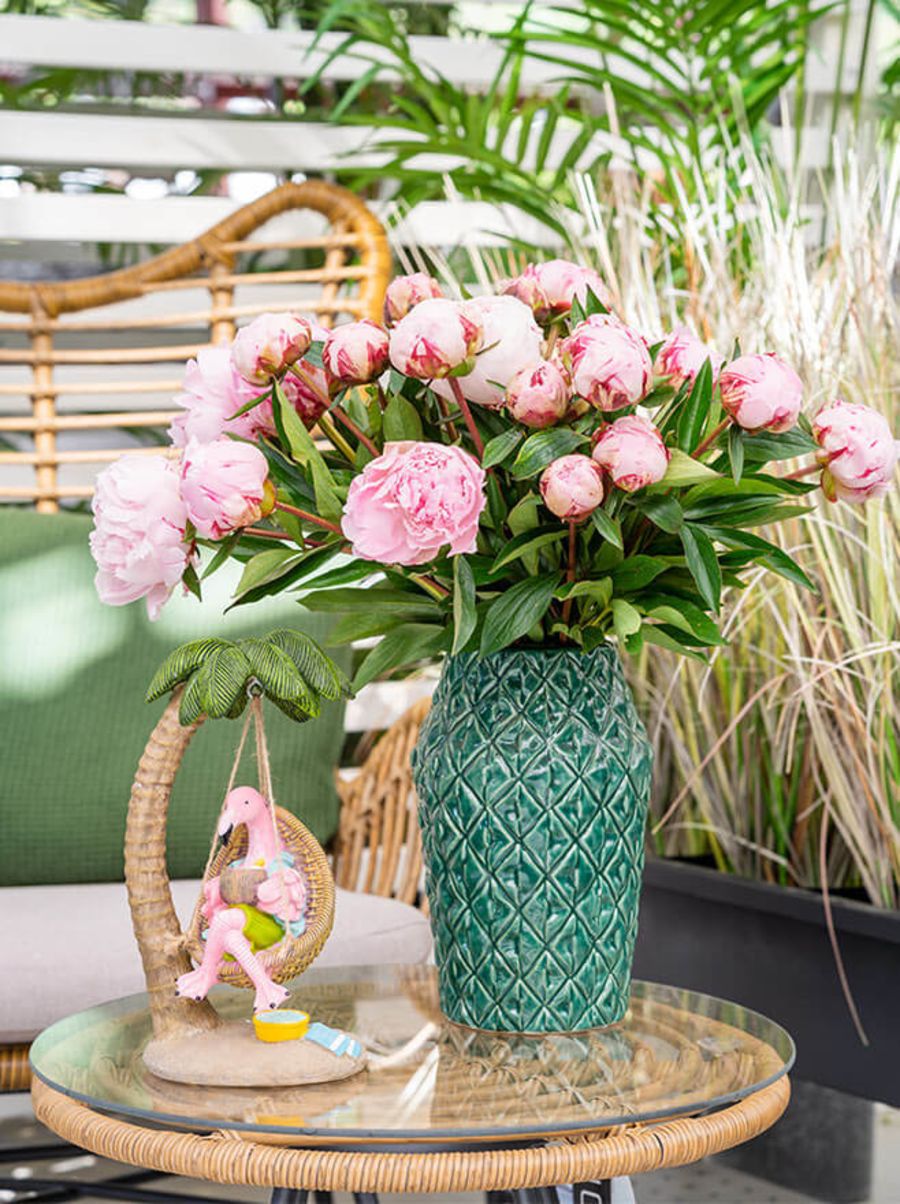 Rosa peoner i grønn vase