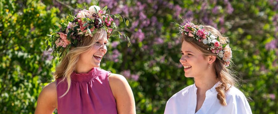 To kvinner med blomsterkranser i håret fra Interflora Norge