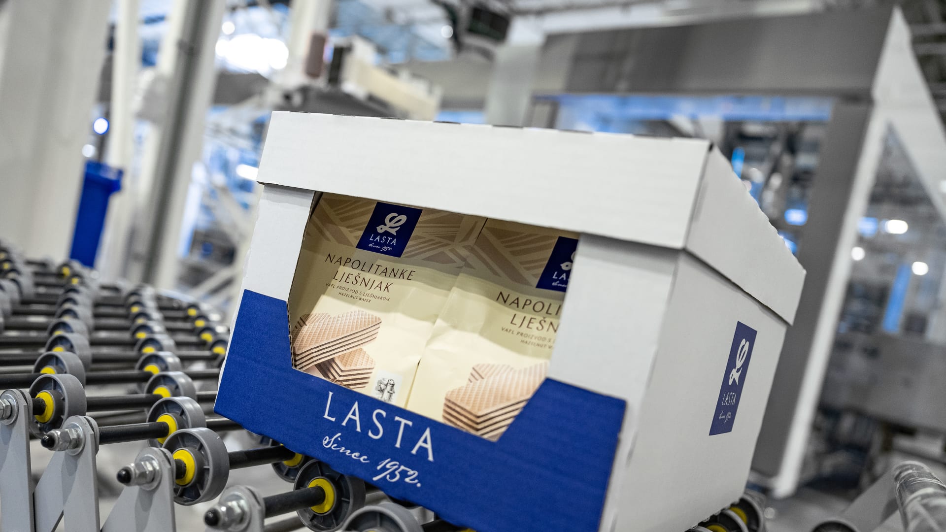 Ein mit Beuteln gefüllter Display-Karton mit Deckel verlässt die Verpackungsmaschine von Schubert.