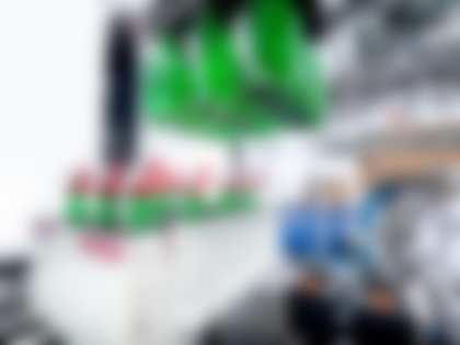 Transparent green bottles with spray caps stand in a grouping unit
