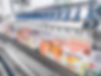 Deux robots TLM-T4 ramassent les sachets flowpack sur une chaîne de groupage et les placent dans les étuis formés. 