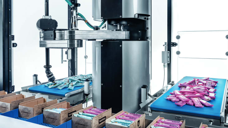 The Cobot tog.519 packing various bars into cartons.