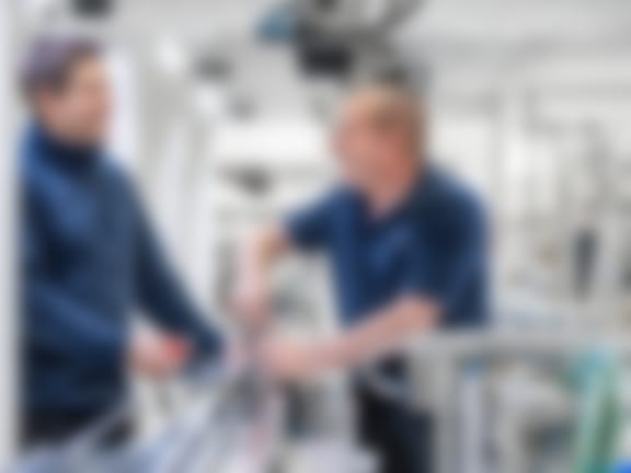 Two employees are working together at a packaging machine