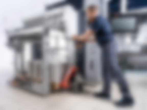 A machine operator pushes a pallet of cardboard blanks into the Comfort Feeder.