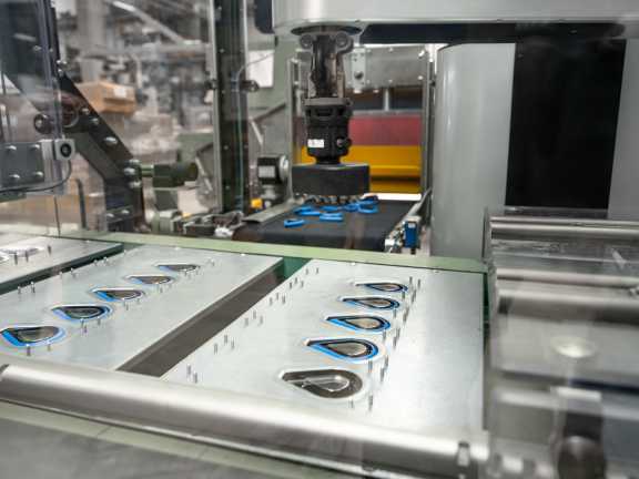 The cobot picks up products, in this case fragrance clips, from a disorganised pile and places them accurately into the designated location.