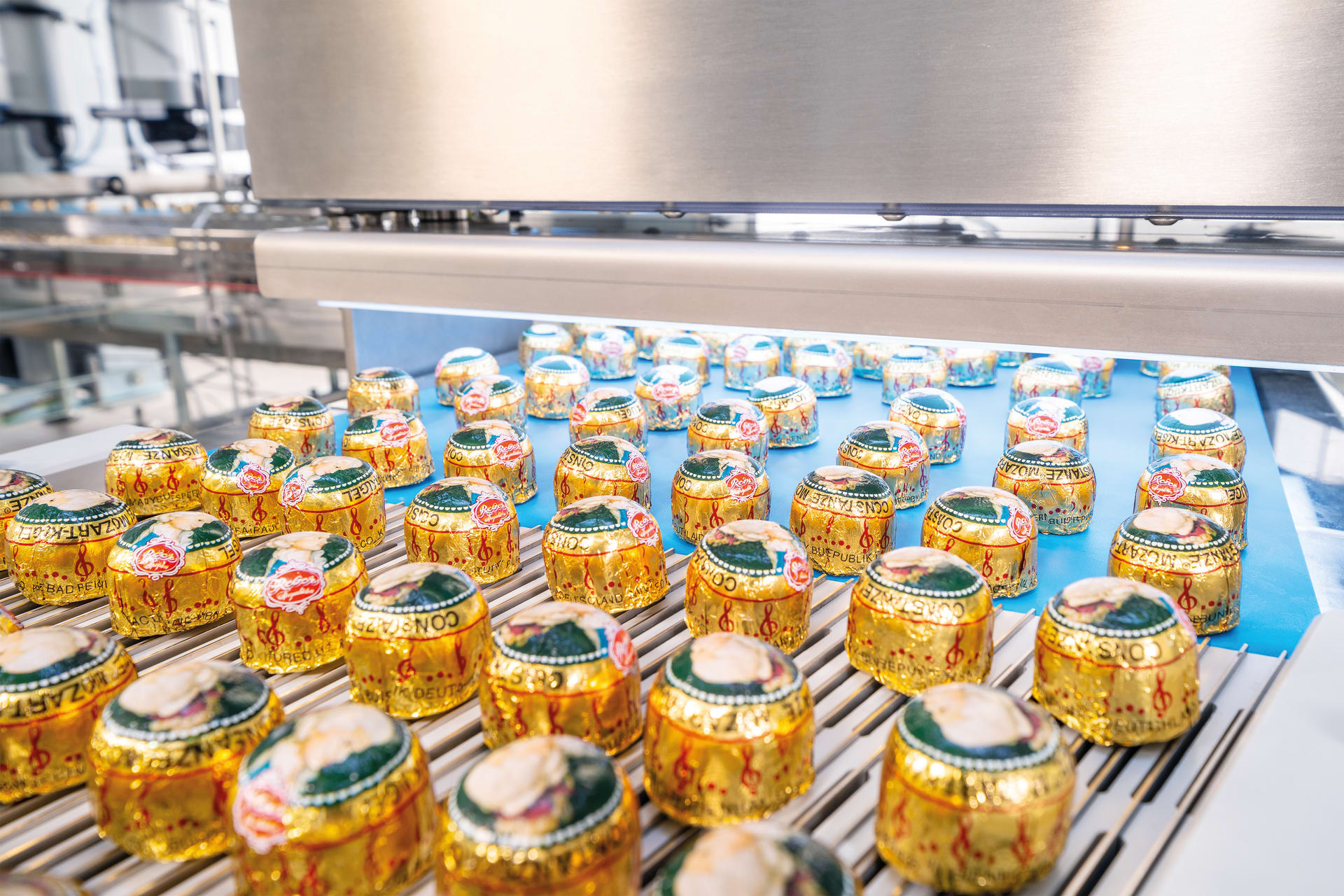 The vision system from Schubert inspects the quality of the Mozart balls arriving on a conveyor belt in a packaging system from Reber.