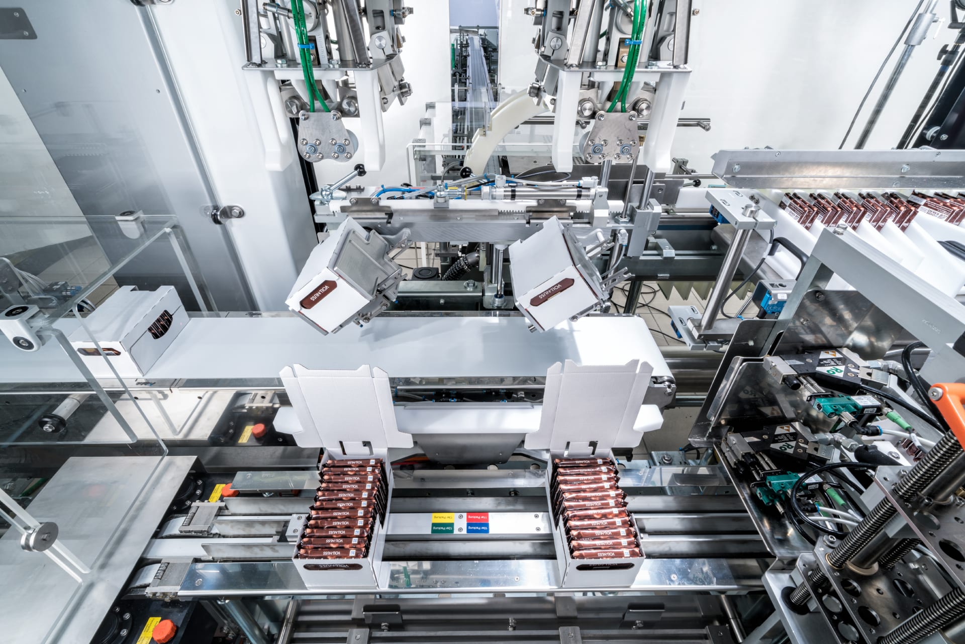 In a Schubert production line, chocolate bars from Ritter Sport are packed in boxes, sealed and turned over.