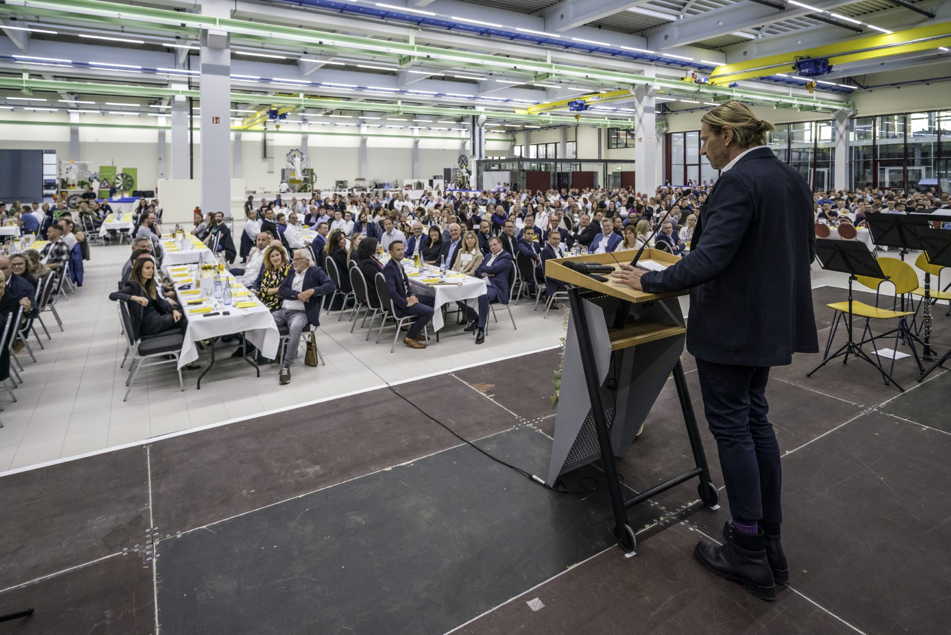 Gerald Schubert hält an einem Podium eine Rede zur Eröffnung der Montagehalle. 