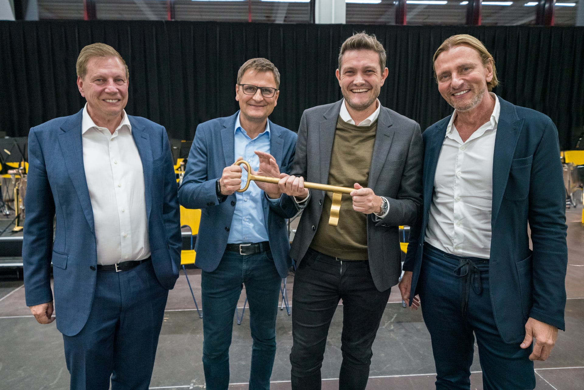 Ralf Schubert, Karl-Heinz Gaukler, Marcus Schindler und Gerald Schubert lachen bei der feierlichen Übergabe des Schlüssels für die Montagehalle. 