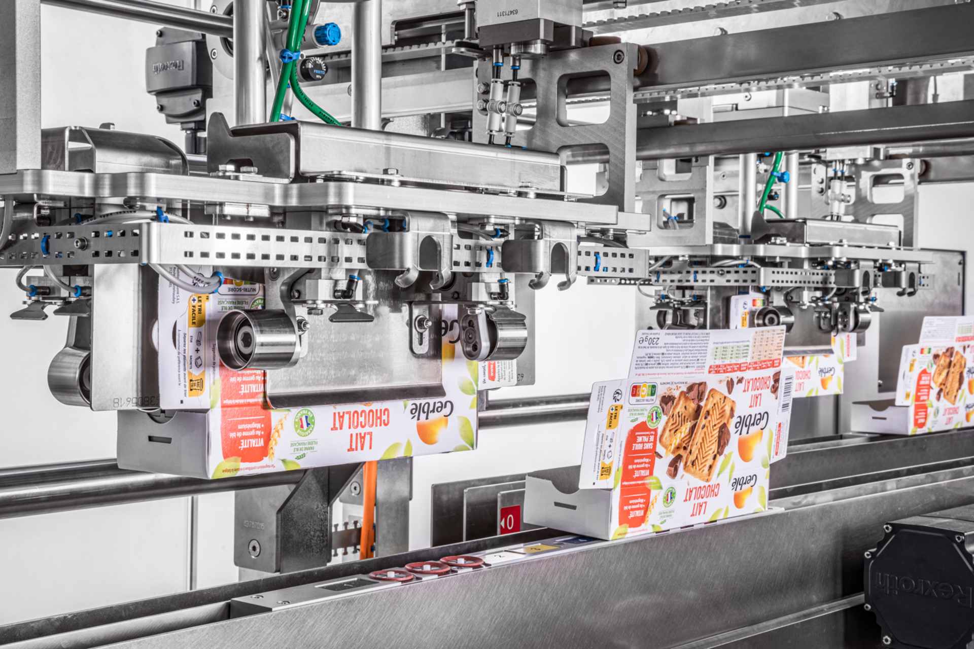 Mehrere Roboter falten Zuschnitte aus Karton zu Schachteln, um sie für die Aufnahme von Produkten vorzubereiten.