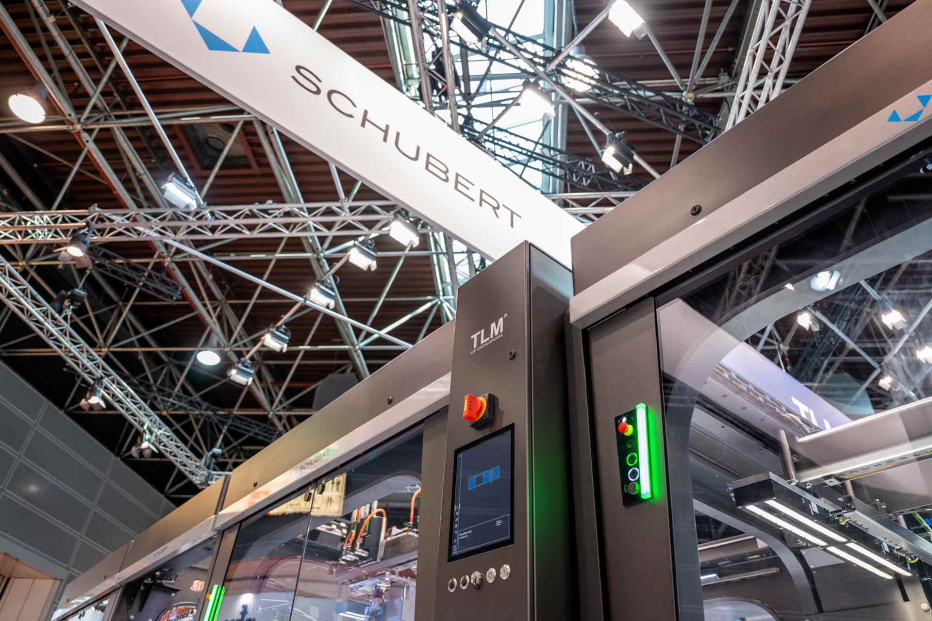 Close-up of a Schubert packaging machine with a digital control and display panel at a trade fair.