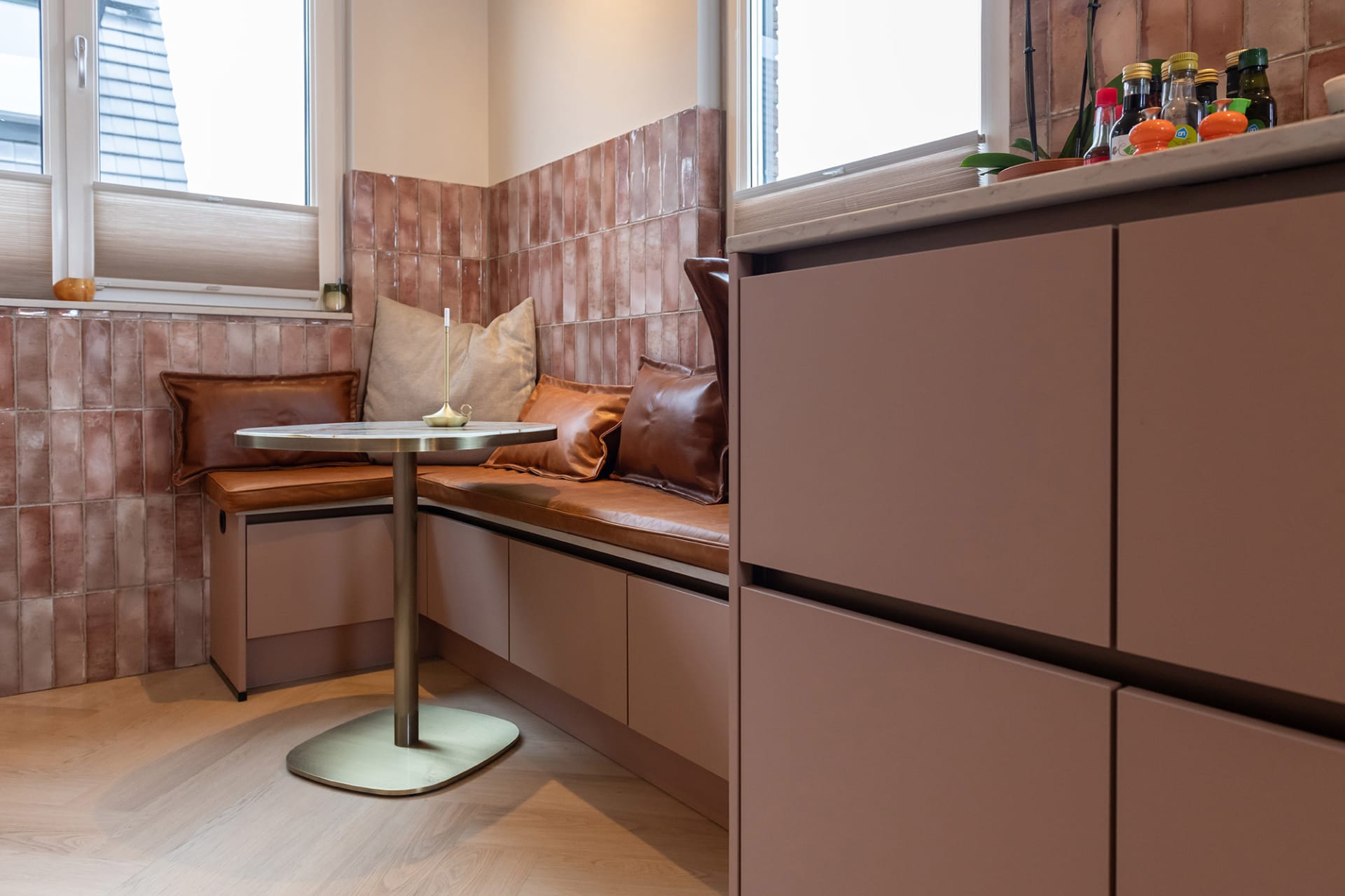 Detail van de greeplijsten en roze fronten in de keuken van Selma