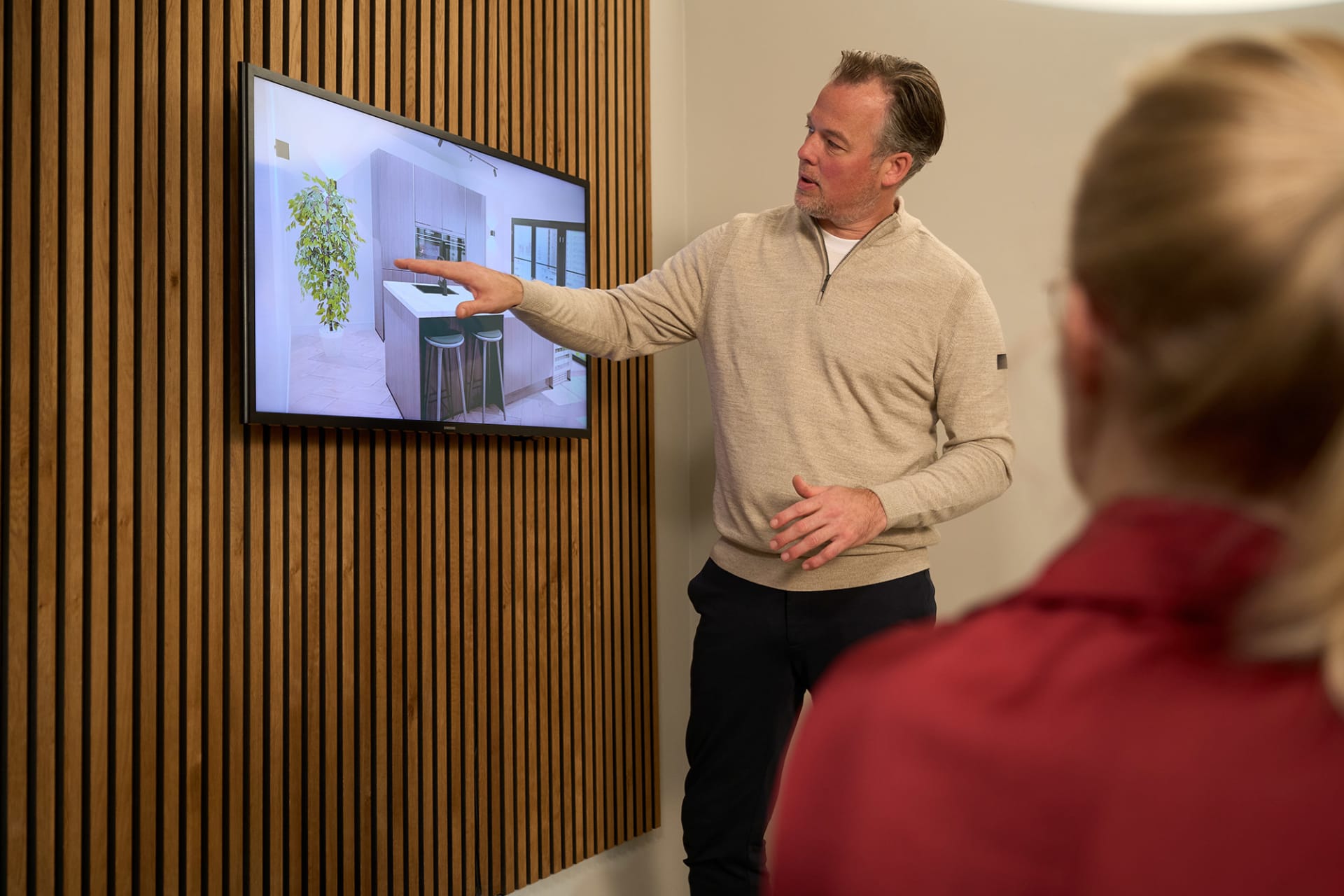 Kitchen4All adviseur laat een 3D-keukenontwerp zien aan een klant