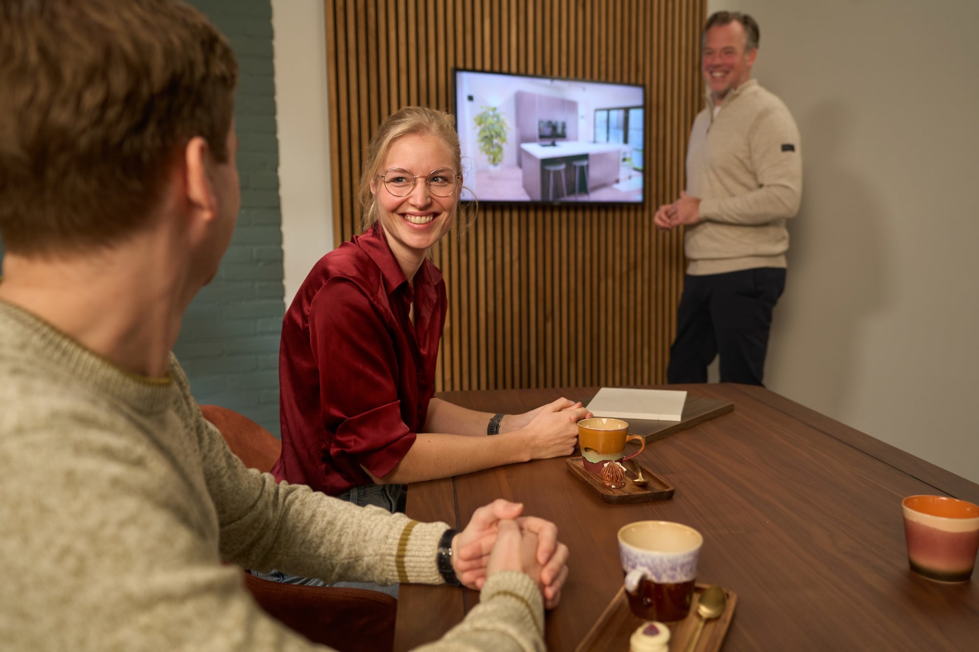 Keukenadviseur toont 3D-ontwerp op scherm aan klant