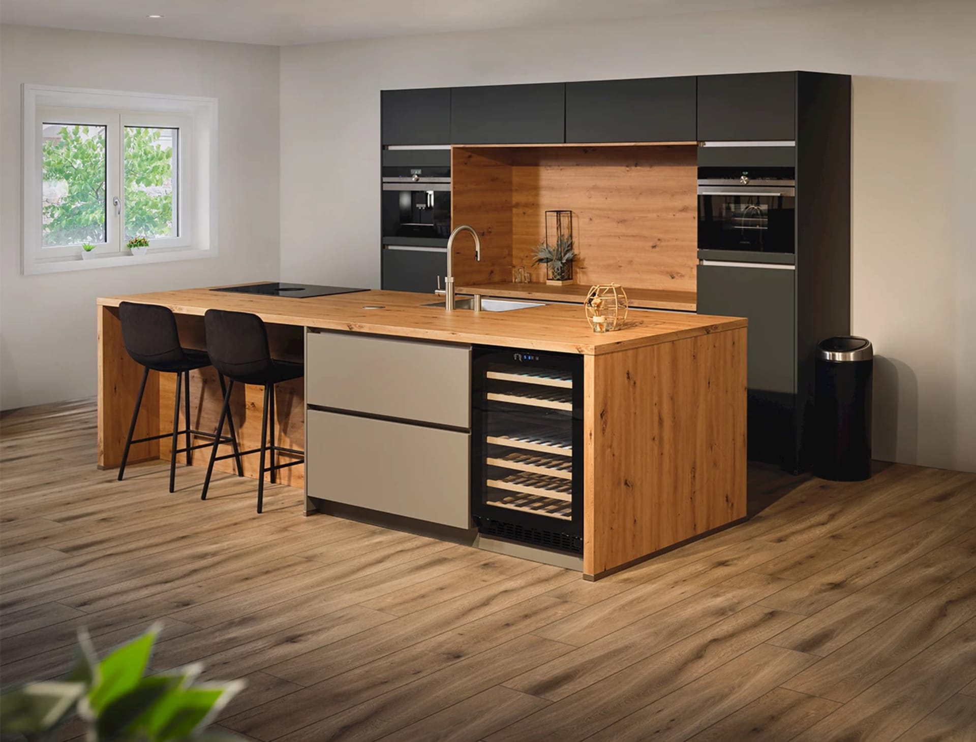 Grote woonkeuken met een houten eiland, barkrukken en antraciet kasten