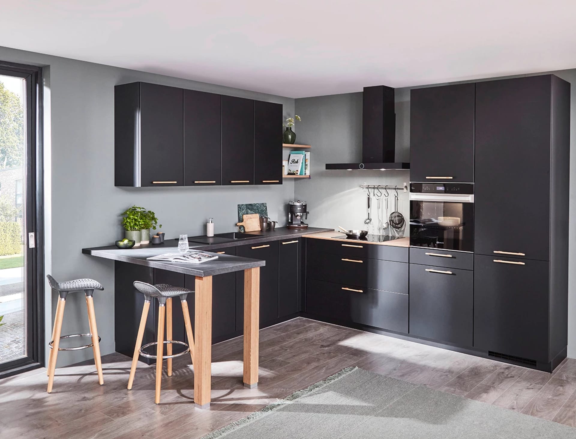 Zwarte hoekkeuken met een houten bar en barkrukken