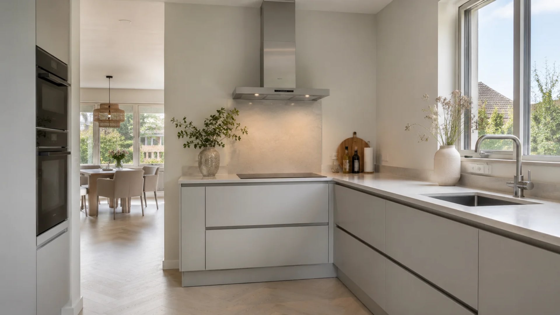 Lichtgrijze keuken met licht werkblad, open naar de eethoek