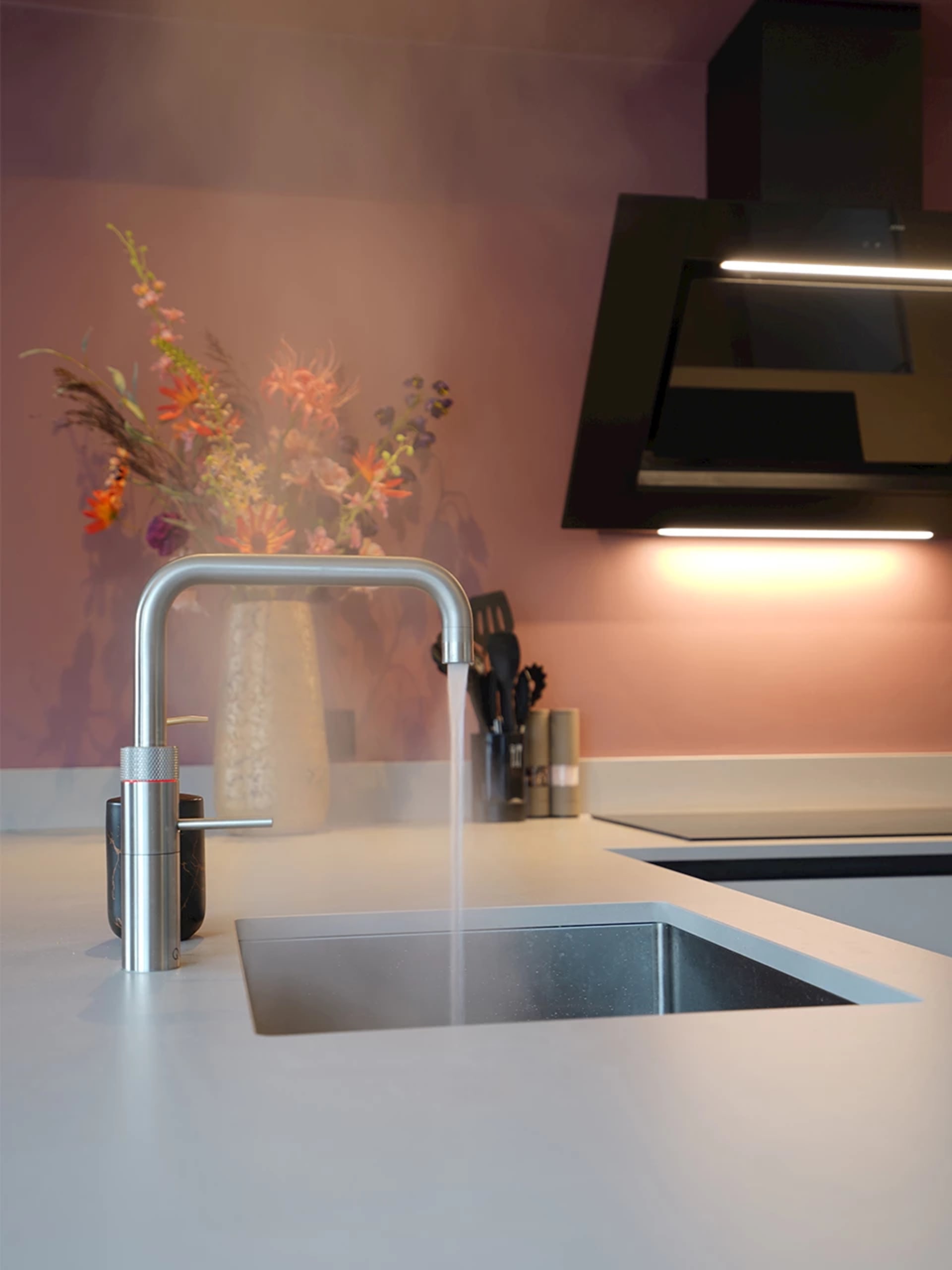 Keukenkraan en spoelbak naast een schoon werkblad