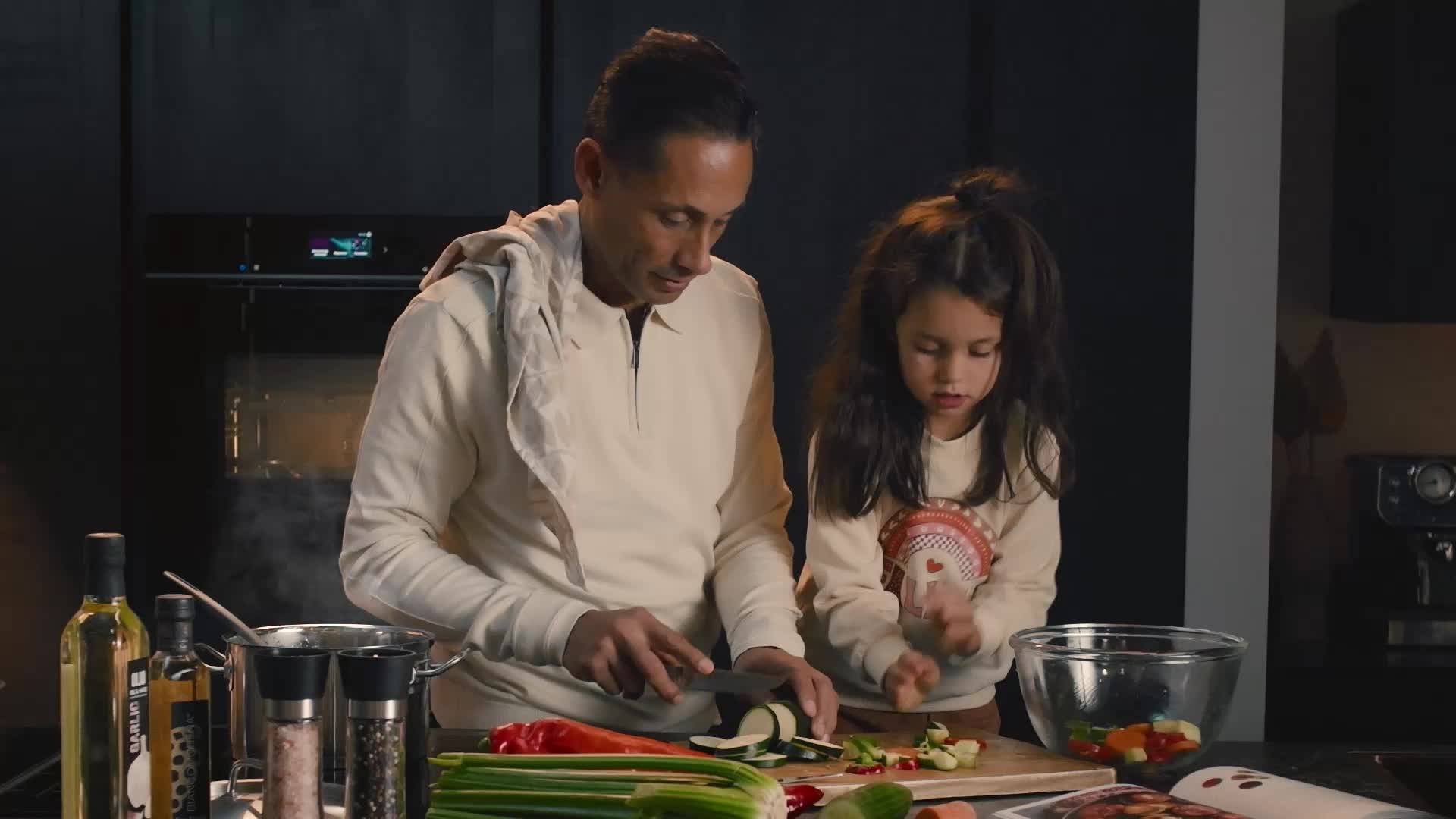 Familie geniet samen van koken in moderne keuken