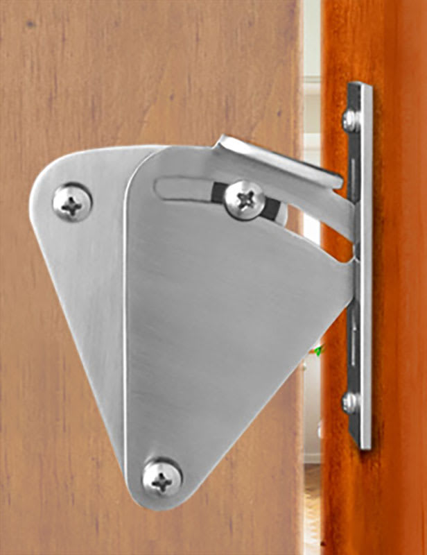 Brushed-metal teardrop latch engaged with a narrow keeper beside a wood door.