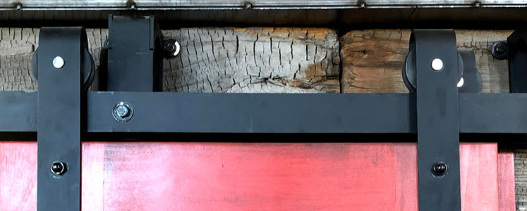 Red sliding barn door hardware in a Rustica showroom