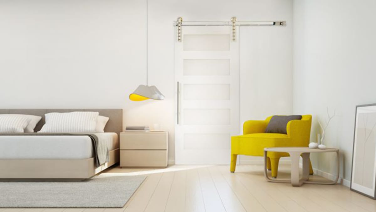 White sliding barn door in a bedroom with a yellow chair