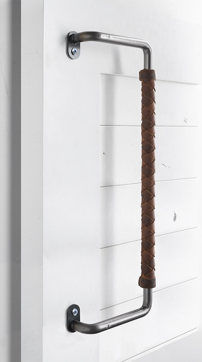 Leather-wrapped door pull on a white barn door