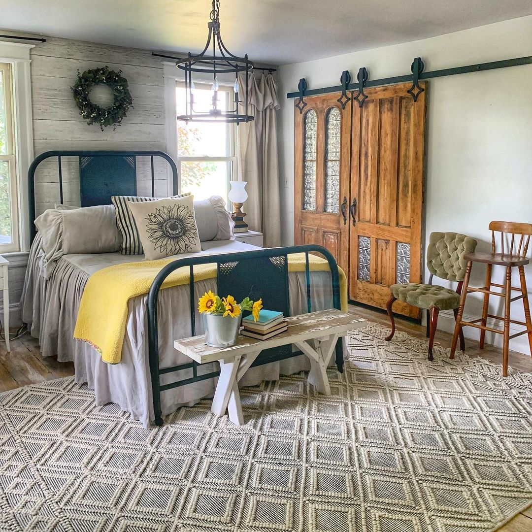 a hallmark worthy, farmhouse bedroom with antique vintage sliding barn doors.