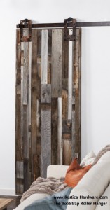 The Bootstrap Roller Hanger in warehouse bronze with a salvaged vertical barn wood barn door