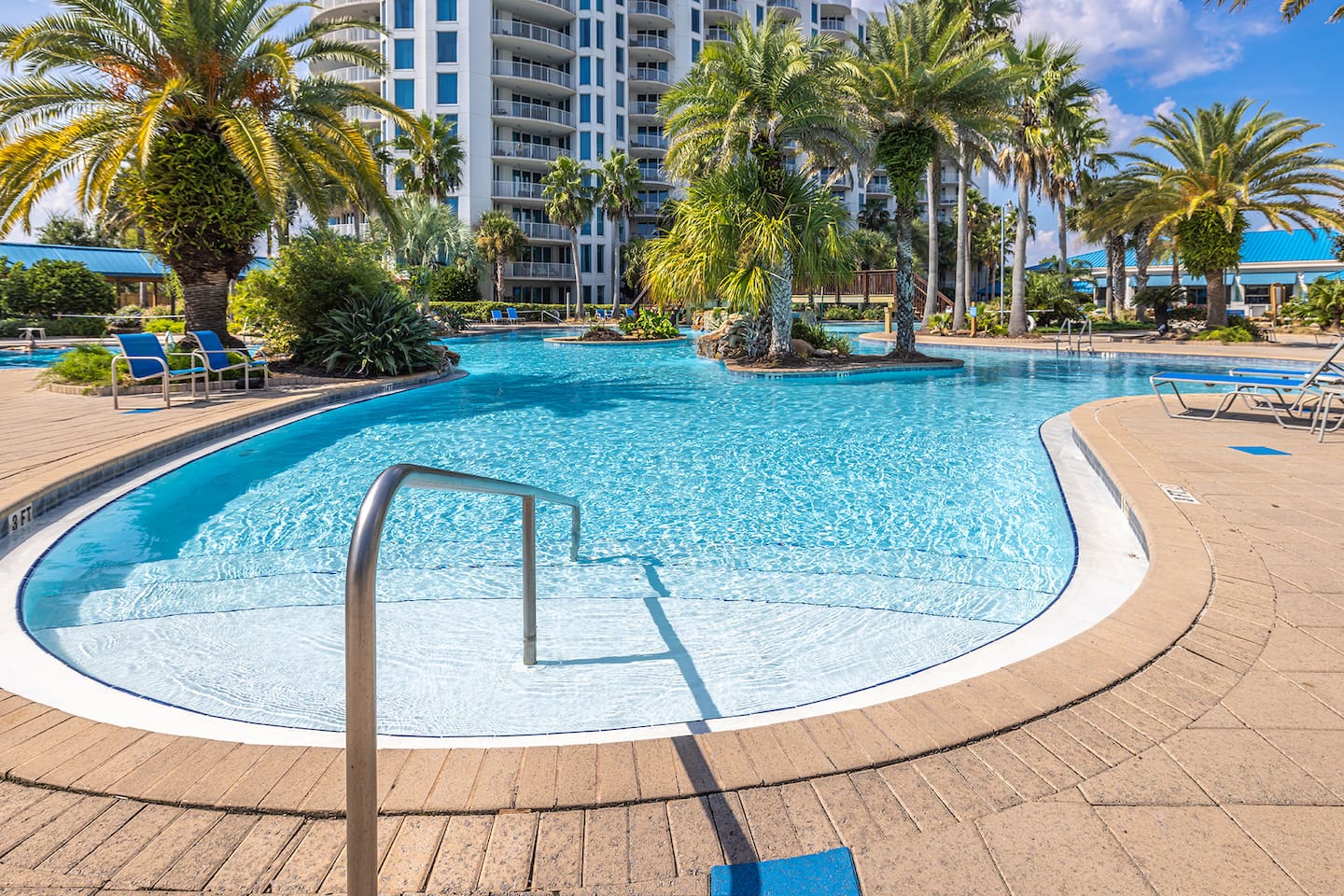 Resort-style pool framed by swaying palms, perfect for sunny afternoons & cooling off between beach days