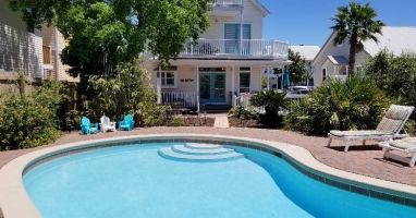 Backyard oasis with pool and dining area.