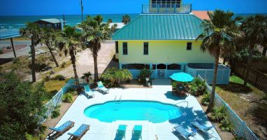 Private pool area with lounge chairs, dining table and umbrella