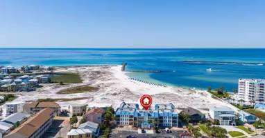 Aerial view showcasing the property's prime beachfront location on Florida's stunning emerald coast, with pristine white sand beaches and turquoise Gulf waters just steps away.