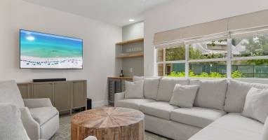 Relax in this cozy, coastal living room with plush seating, natural textures, and a built-in wine bar.