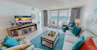 Unwind in your oceanfront living room where turquoise accents mirror the sea views through floor-to-ceiling windows onto your private balcony.