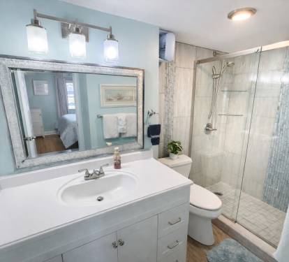 Updated primary bathroom with spacious walk-in shower with coastal finishes.