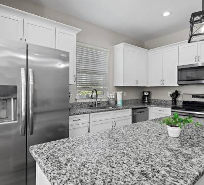 The kitchen is equipped with a large two-door refrigerator with ice maker, stove, oven, coffee-maker and dishwasher.