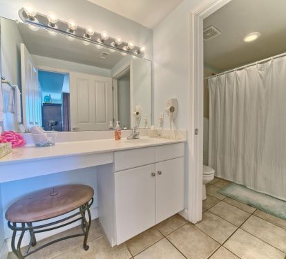 Master bath separated by a door to tub/toilet from vanity sink area. 