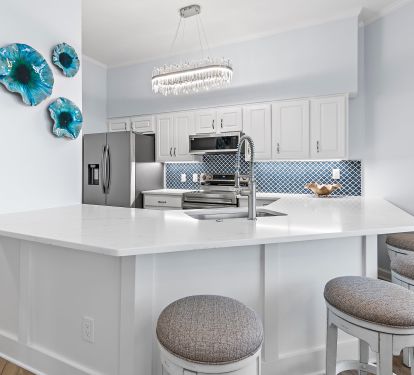 Kitchen with granite counters, stainless appliances, and bar stools