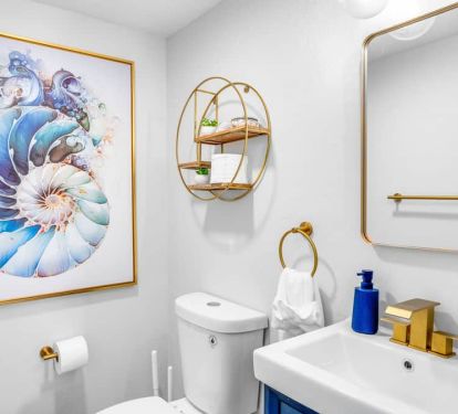 Step into our main-floor half bath&mdash;gold-and-blue art and a statement shell d&eacute;cor piece