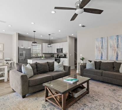 The open-concept living area includes a kitchen island, dining space, and kitchen.