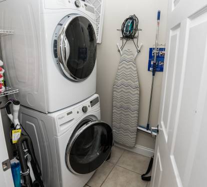 A Full-Size Stack Washer & Dryer in The Laundry Room,  located in the enterance hall.  