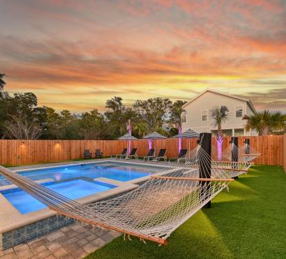Landscape lighting at sunset and poolside hammocks
