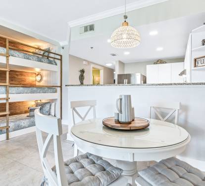 Seating for four at the table with views of the TV and pool. 