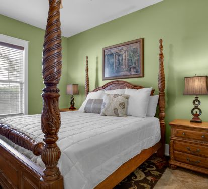 1st floor bedroom feautures a king sized bed and has a ceiling fan.