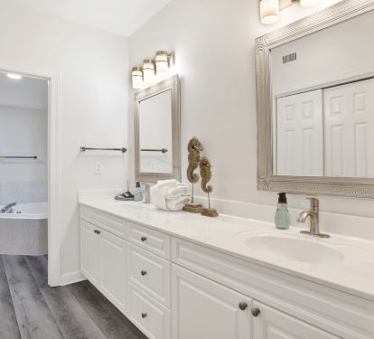 Dressing area with double sink, large walk-in closet, and bathroom with jetted tub and shower