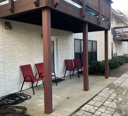Back patio has chairs, water hose to clean sandy feet and faces the pool/tennis
